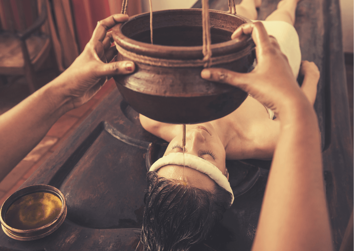 Frau mit langen Haaren unterzieht sich einer Ayurveda Behandlung
